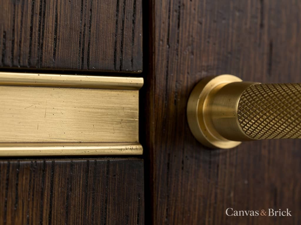 Unlacquered antique brass inlay and knurled pull set into dark timber