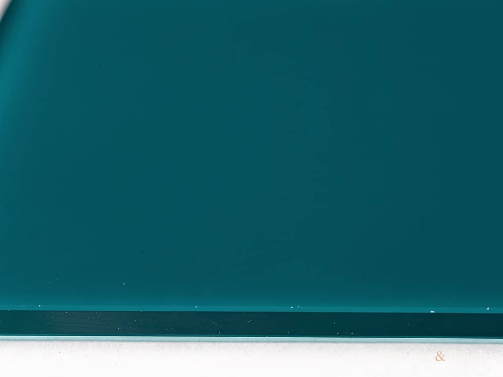 Back-painted lacquered glass panel in deep teal with a flawless high-gloss surface