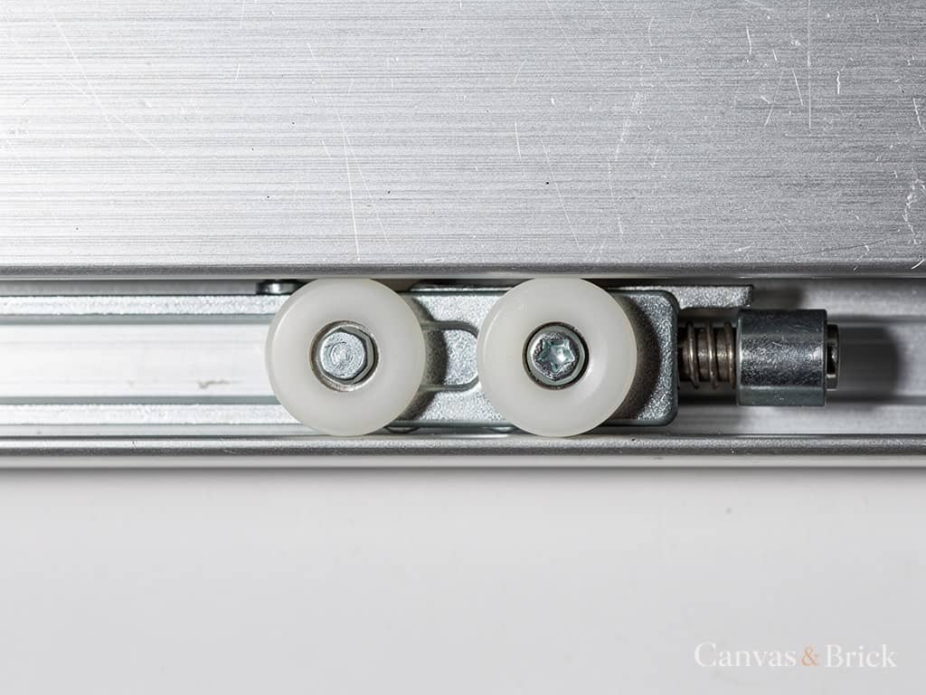 Top-hung sliding wardrobe track with its roller carriage and soft-close damper